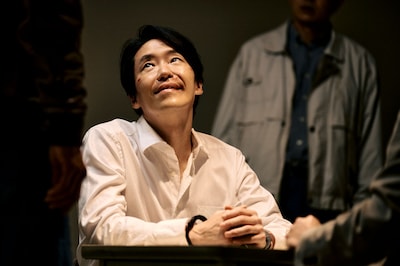 「TOKYO BURST-犯罪都市-」新場面写真。取り調べを受けながらも余裕の笑みを浮かべるキム・フン（演：オム・ギジュン）