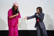 映画「炎上」初日舞台挨拶より、長久允（左）の“炎上カラー”のファッションを紹介する森七菜（右）