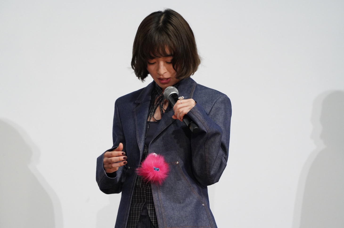 映画「炎上」初日舞台挨拶より、衣装に付けた“炎上ちゃん”を見る森七菜