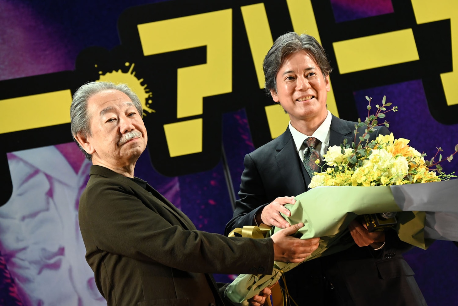 「ミステリー・アリーナ」原作者・深水黎一郎（左）から花束を受け取った唐沢寿明（右）