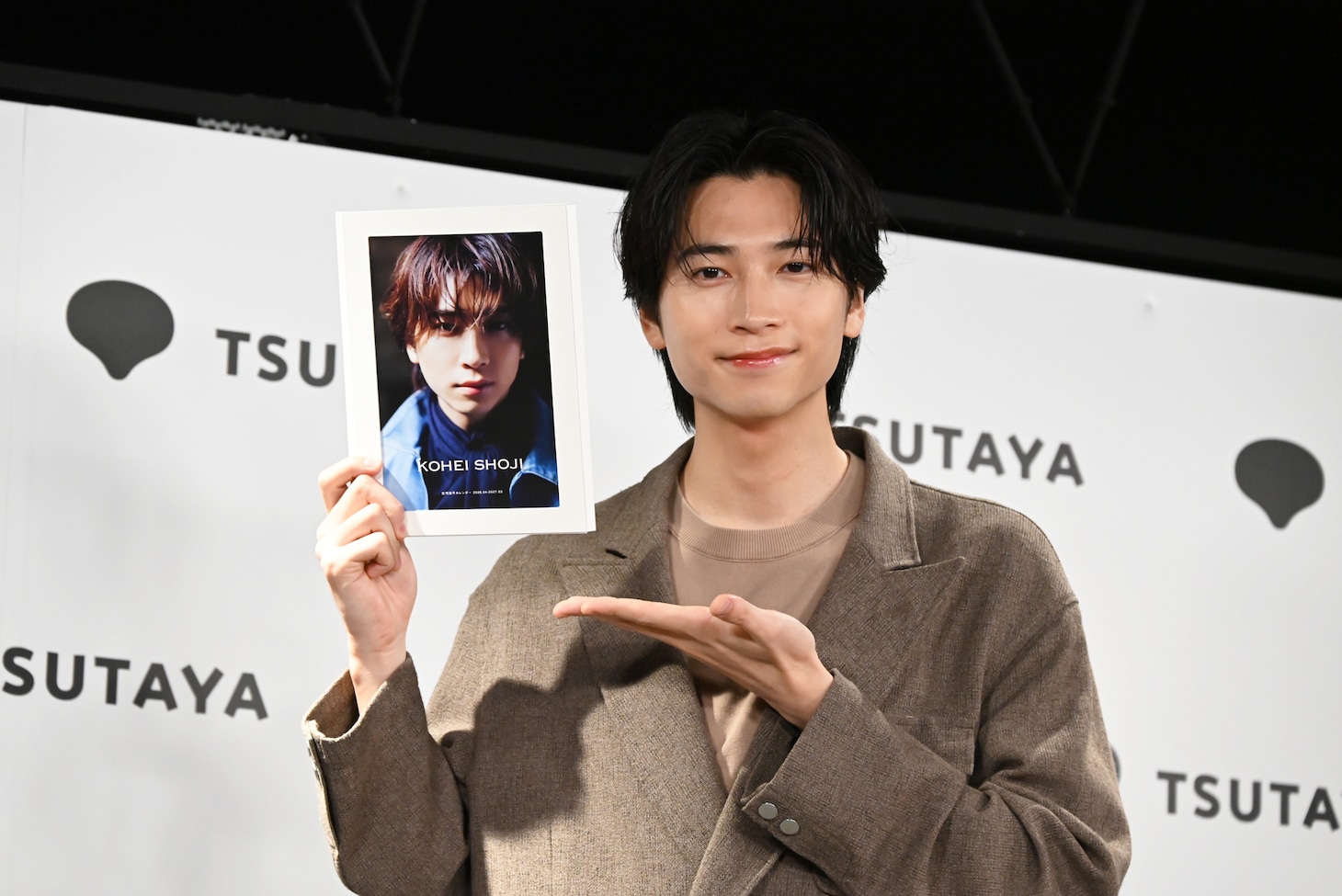 カレンダーの表紙を見せる庄司浩平