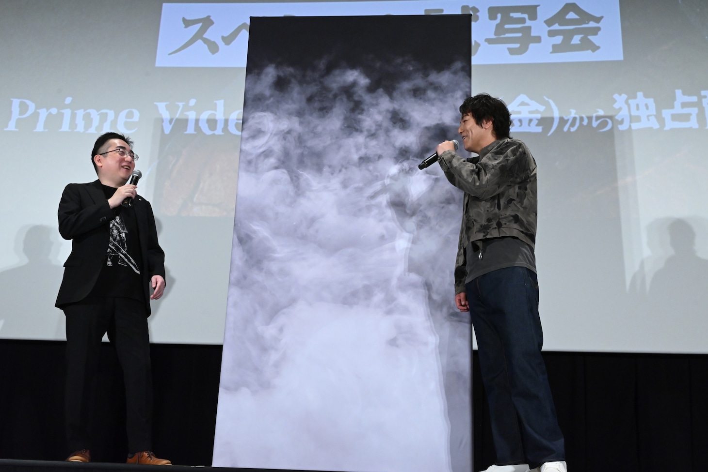 「クイズに全問正解できなければ、フォトセッション時にはパネルの裏に行っていただきます」と告げられ笑う狩野英孝（右）