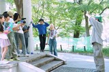 「映画とわたしの5日間」より、“雨降らし”を水鉄砲で演出する様子。仲野太賀（右）は自ら水を浴びながら「いい感じだ！」とOKサインを出す
