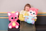 映画「ベベフィン・ザ・ムービー：うたとまほうのピンキッツワールド」左からピンキッツのぬいぐるみ、フィンのぬいぐるみを抱えたゲスト声優・かなで（3時のヒロイン）