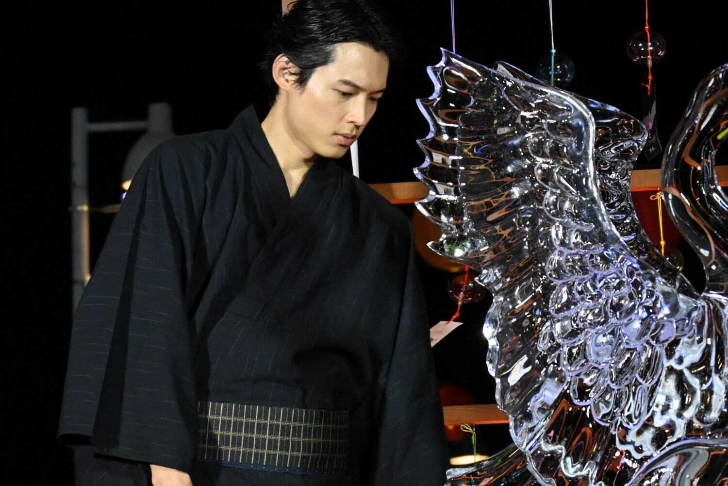 白鳥”と“コウモリ”を模した氷の彫刻をじっくり観察する松村北斗 [画像