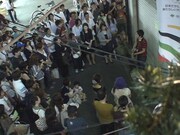 写真は8月7日に下北沢駅北口にて行われた路上ライブの模様。ミドリカワファンや通りすがりの人々など、多数の観客が彼の演奏に耳を傾けた。