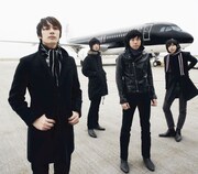 THE BAWDIESの4人。後ろは飛行機。