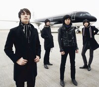 THE BAWDIESの4人。後ろは飛行機。
