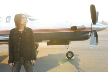 全国のクラブを飛び回るsugiurumn。後ろは飛行機。