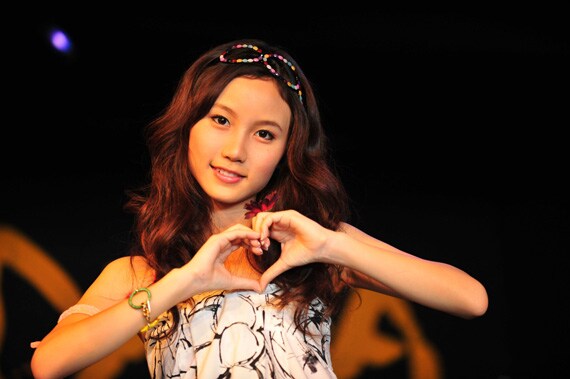 指先でハートを形作ってファンを挑発するMay。キュートな歌声とルックスにファン急増中だ。