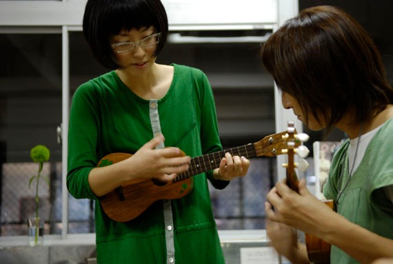 写真は2008年8月に東京・世田谷ものづくり学校で行われたウクレレ教室の様子。あやの先生は50名を超える生徒に自身のナンバー「たんぽぽ」を教え、最後にみんなで演奏した。