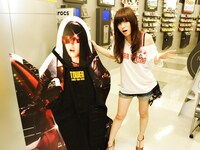 初回盤ジャケットのおぼつかない足取りを再現するアイラ（本物）とコピーロボット（立て看板）。