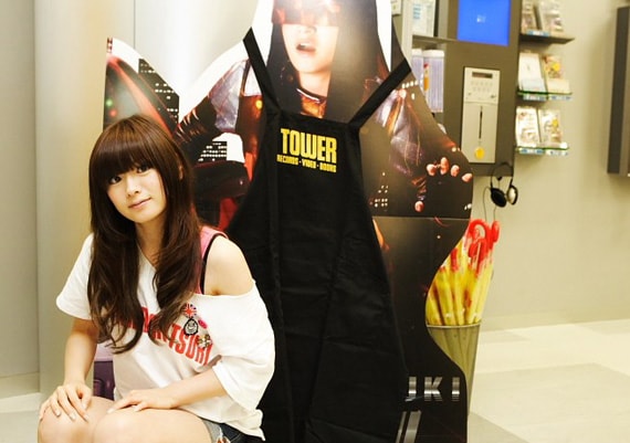 にっこりほほえむアイラ（本物）とコピーロボット（立て看板）。ナタリースタッフも同日夕方過ぎにタワーレコード秋葉原店に足を運んだがアイラ本人の姿はなく、コピーロボットのみがけなげに立ち続けていた。