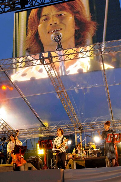 歌うくるり。上はモニターに映る岸田繁。