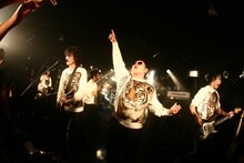 満員の渋谷La.mamaでトラ顔トレーナーを着込み、ダイノジとともにパフォーマンスを行う9mm Parabellum Bullet。