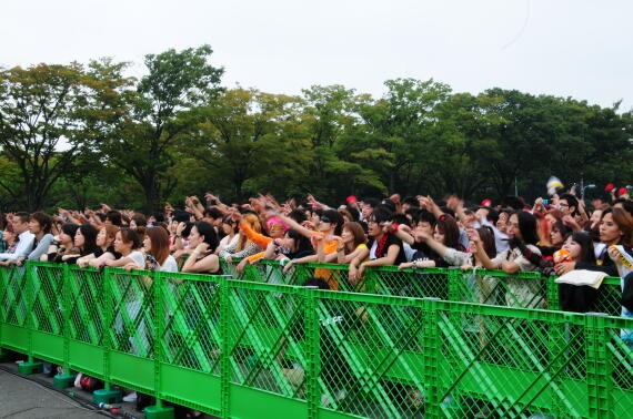 会見スタート前、ライブ映像に熱狂するファン。この日は約1万人が詰め掛け、入れなかったファンは会場の外から様子を見守った。