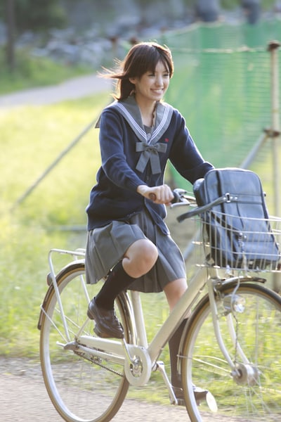 自転車で颯爽と駆けるセーラー服姿のアッキーナ。