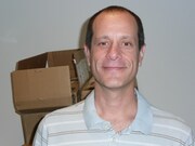 段ボールが積まれた事務所でPOLYSICSの魅力を熱く語るMySpaceのJ・スキャヴォ氏。