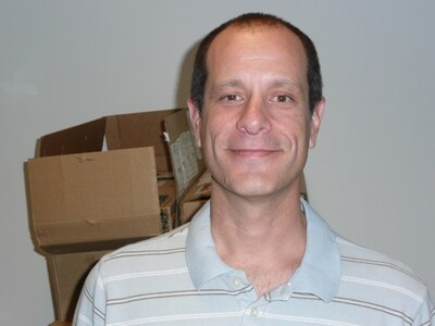 段ボールが積まれた事務所でPOLYSICSの魅力を熱く語るMySpaceのJ・スキャヴォ氏。