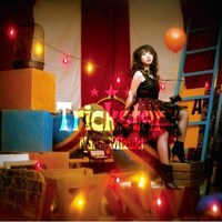 写真は10月1日に発売されたシングル「Trickster」。12月15日にはライブ映像集「NANA MIZUKI LIVE FIGHTER」がBlu-rayとDVD（2種）でリリースされる。