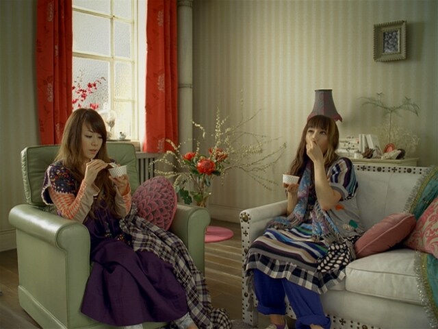 「MOW」を食べる亜美と由美。由美の頭上に見えるのは帽子ではなくランプの傘。