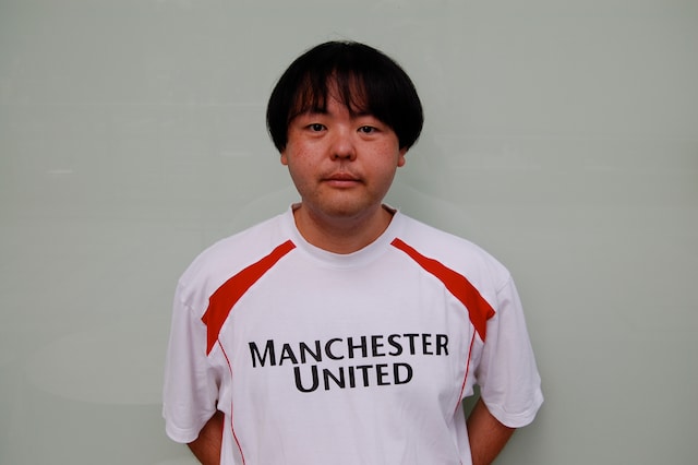 マンチェスター・ユナイテッドのTシャツを着たA.K.I.PRODUCTIONS。