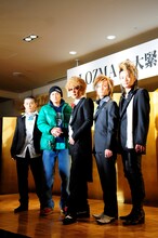 固い握手をする初代＆二代目DJ OZMA。会見中、二代目の携帯電話が突然鳴り出すハプニングも。