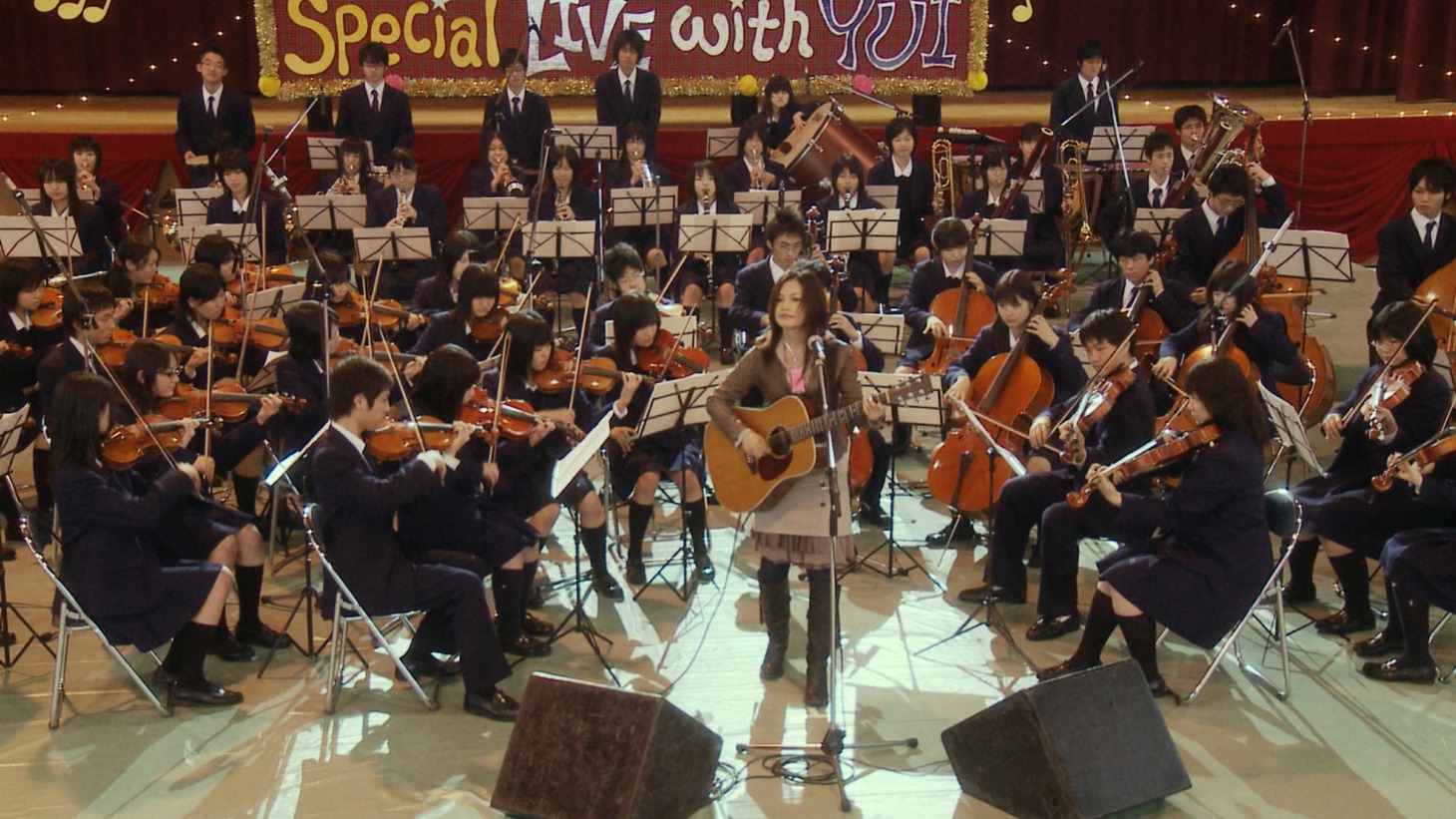 CMに出演したYUIと管弦楽部の生徒たち。