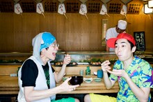 なにかおいしそうなものにかぶりつく□□□の村田シゲ（写真左）と三浦康嗣（右）。