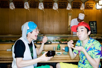 なにかおいしそうなものにかぶりつく□□□の村田シゲ（写真左）と三浦康嗣（右）。