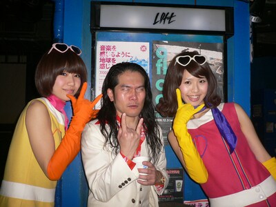 写真は新宿LOFTで行われた「ロマンポルシェ。2009『合法ライブ』」での一コマ。背後のポスターの「音楽を感じるように、地球を感じよう。」というコピーどおりに地球を感じている掟の表情が印象的。