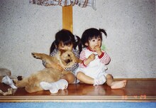 幼少時代の倖田姉妹。左が來未で右がmisono、來未が抱いているのが犬だ。