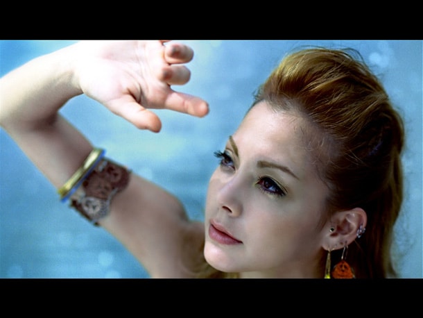 まばゆそうに太陽を見上げるアンナ。アンナの白い肌が大自然にくっきりと浮かび上がる。