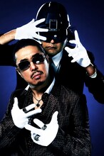 Bro.TOM（写真後方）