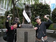 ソロアーティスト、クノシンジ（写真左）は今年4月、ハチ公前～地元名古屋～下北沢を自転車で巡るツアーを行った。写真はスタート直前、ハチ公との記念ショット。