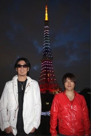虹色に染まった東京タワーを背にするコブクロ。