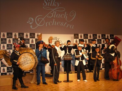 新CM本編披露後のトークセッションでは「オーケストラのボスは誰か？」という質問に、ムッシュかまやつ（写真左端奥）が「指揮者の吉川晃司さんでしょ」とコメント。それに対し吉川は「いえ、かまやつさんです」と互いに譲らず。報道陣の笑いを誘った。