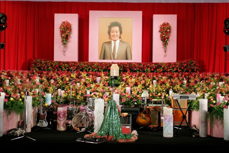 式場内は紅白の横断幕をバックに、多数の花やCandle JUNEの手による100本近いキャンドルが飾られた。