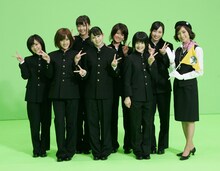 写真はPV撮影中のひとコマ。大江アナのバスガイド姿はもちろん、Berryzメンバーの男前な学ラン姿にも注目。初めて学ランを着た熊井友理奈（写真左から3番目）は「学ランがこんなに暑くて重いとは思わなかった…男の子って大変ですね（笑）」と感想を語っている。