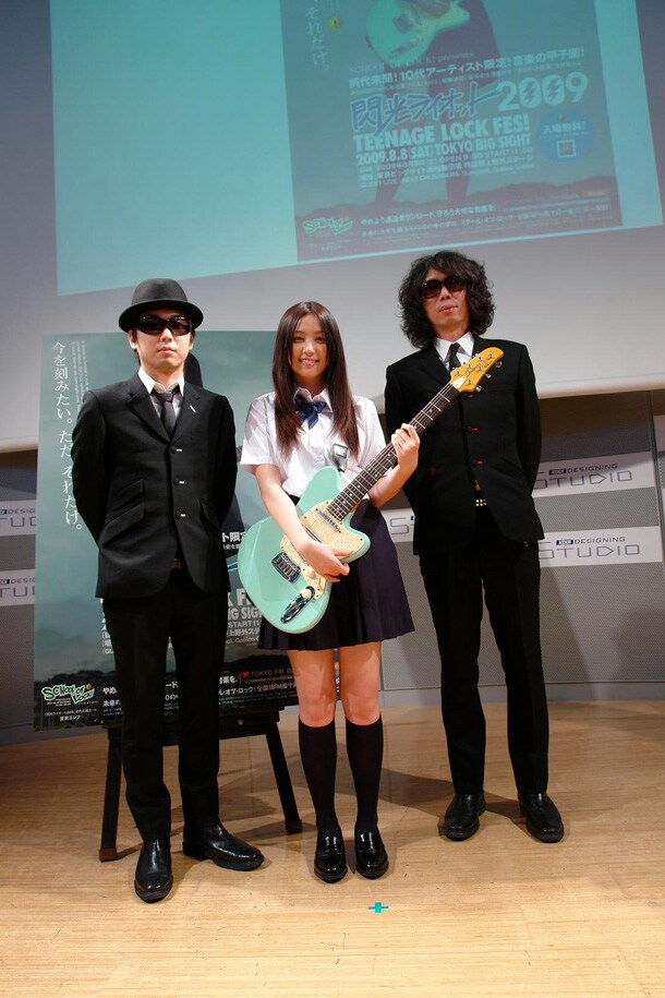 写真は5月26日に行われた記者会見の模様。初代応援ガールに選ばれた夏未エレナ（写真中央）とやましげ校長（左）、やしろ教頭（右）の3ショット。