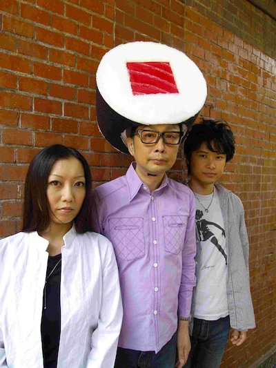 サエキけんぞうとClub Je t'aime。サエキの頭には、自身が2003年にリリースしたフレンチカバーアルバム「スシ頭の男」にあわせた、スシのかぶりものが。