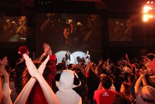 会場に現れたYOSHIKIをXジャンプのようなポーズで迎えるファン。