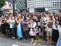 一斉に街頭ビジョンにカメラを向ける渋谷の若者たち。