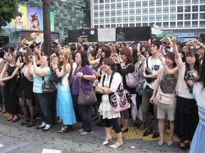 一斉に街頭ビジョンにカメラを向ける渋谷の若者たち。