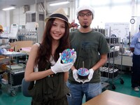 サインを施したCDを手にほほえむMayと、白い帽子をしっかりかぶって身も心も工場員となったDaichi。