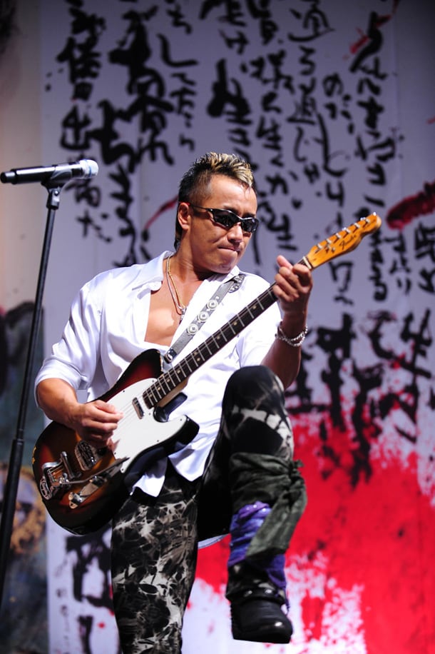 敵のみぞおちに膝を突き立てる格闘家のようなポーズでテレキャスターをかき鳴らす長渕剛。