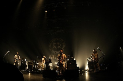 この日のユニコーンは、夏フェス仕様の衣装に衣替え。白地に青の粗いヒッコリー生地で作られた半袖のつなぎで、背中にはそれぞれのイニシャルが異なる色でプリントされていた（photo by YOJI KAWADA）。