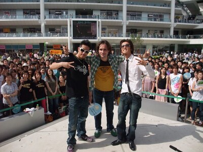 肩を組み、仲良しぶりをアピールするヒルクライムとスコット・マーフィー。2組は明日7月22日に東京・お台場合衆国オダイバ州フジテレビランド1F広場で開催されるライブイベントでも競演する。