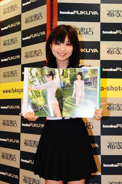 お気に入りのページを開くおがまな。「実はまったく泳げないので、そろそろ泳げるようになりたいです。写真集では腰くらいまで水に入っても、自分的には溺れてる感じなんですよ（笑）」と苦笑いをした。