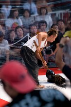 詩画実演中の長渕剛。客席に墨が飛ぶことを考慮し、前方の観客にはビニール製雨合羽が配布された。